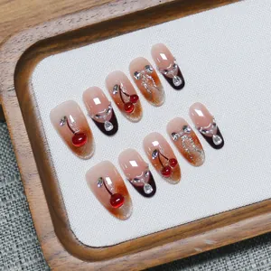 Handmade press-on nails set with cherry 3D art, rhinestones, and orange gradient finish