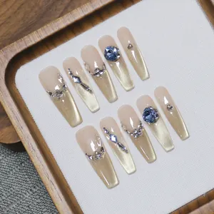 Luxury handmade cat-eye press-on nails with blue gemstones and champagne gold glitter