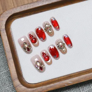 Handmade red cat eye press-on nails with 3D lion dance and rhinestone snowflake charms