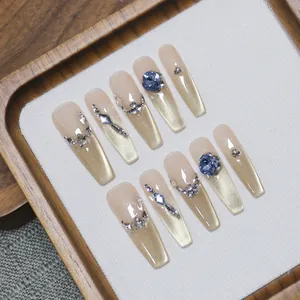 Handmade cat-eye coffin press-on nails with champagne gradient and luxury blue crystals