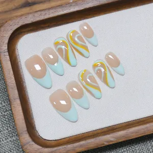 Handmade almond press-on nails with blue French tips and yellow hand-painted wavy patterns