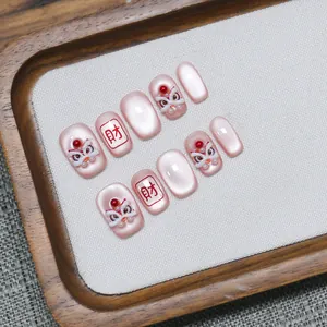 Pink cat-eye press-on nails with 3D lion dance motif and lucky charm characters