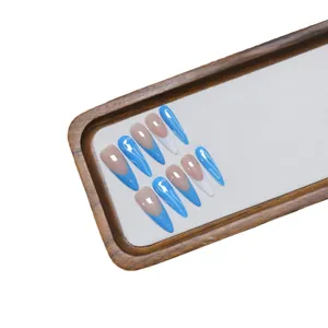 Unghie finte fatte a mano a mandorla con punte French blu e motivi a onde bianche