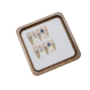 Luxurious cat eye press-on nails set with blue gems and gold gradient on long coffin shape