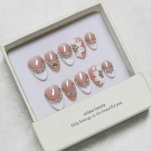 French almond press-on nails with 3D white flowers and sparkling rhinestones