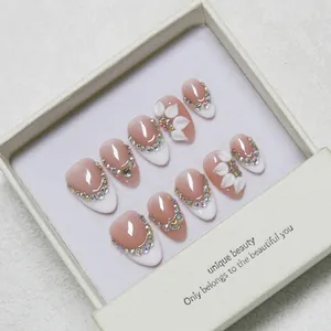 French almond press-on nails with 3D floral carving and rhinestones in a gift box