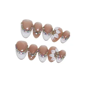 Handmade almond press-on nails with French tips, colorful rhinestones, and 3D floral accents