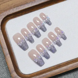 Unghie finte fatte a mano con glitter viola, fiocco 3D e finitura sfumata rosa