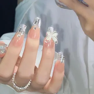 Luxurious handmade press-on nails with silver glitter, rhinestones, and white cat-eye bow