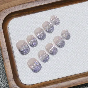 Unghie finte fatte a mano rosa nude con sfumature glitter viola e fiocchi olo 3D
