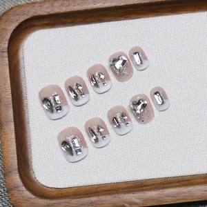 French tip press-on nails with silver glitter hearts and rhinestones on nude base