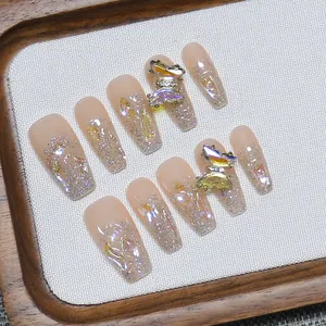 Handmade nude press-on nails with 3D metal butterfly charms and aurora glitter finish