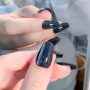 Macro view of navy blue cat eye press-on nails with sparkling glitter in coffin shape