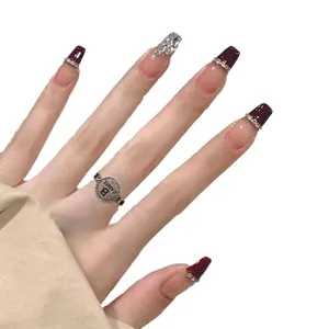 Handmade cherry red French press-on nails with silver glitter and rhinestone accents