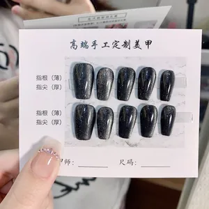 Detailed view of handmade short cat eye press-on nails in deep gray glitter finish