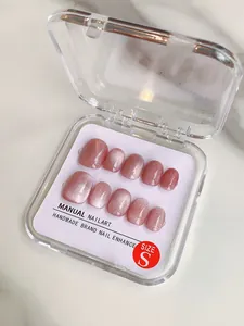 Macro view of handmade pink cat-eye press-on nails in transparent box with size S label