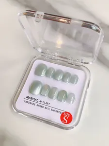 Detail of light green cat-eye press-on nails in an S-size square storage box