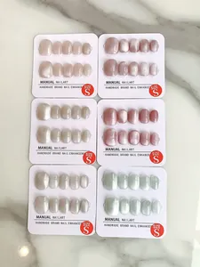 Detailed set of handmade cat-eye press-on nails in size S on white marble background