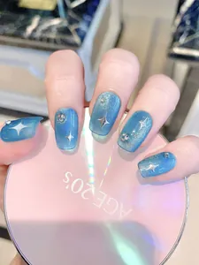 Detailed macro view of blue cat-eye nails with silver stars and shimmering rhinestones