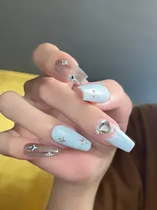 Detail of long coffin nails with blue finish, silver stars and a large heart-shaped crystal
