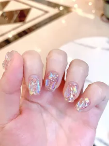 Detalle macro de uñas postizas holográficas aurora con lentejuelas láser y purpurina fina