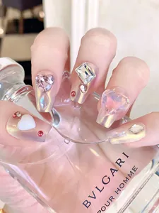 Gros plan sur de faux ongles cercueil avec fini aurore et strass en forme de cœur