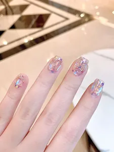 Vista detallada de uñas postizas con purpurina aurora, lentejuelas iridiscentes y forma ovalada