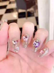 Detail of dreamcatcher glitter press-on nails with sparkling pink heart rhinestones