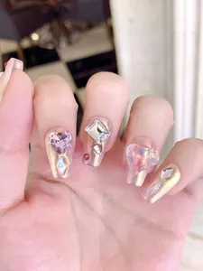 Détail d'ongles faits main cœur mocha avec strass 3D et finition scintillante effet aurora