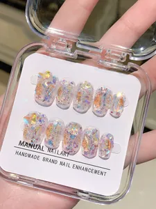 Detalle de 10 uñas postizas hechas a mano con purpurina aurora, lentejuelas y estuche