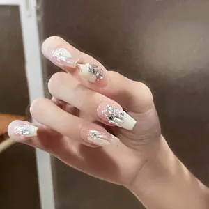 Macro detail of long coffin press-on nails with silver glitter and 3D rhinestones