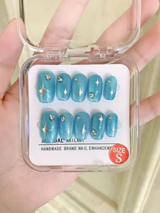 Detail of blue cat-eye handmade press-on nails with silver star and rhinestone accents