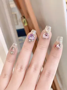Macro shot of coffin press-on nails with sparkling glitter and 3D heart rhinestones