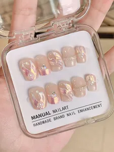 Close-up of handmade aurora pink press-on nails with 3D water ripples and pearls