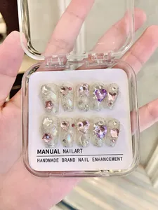 Close-up of handmade dreamcatcher press-on nails with glitter, rhinestones and gems