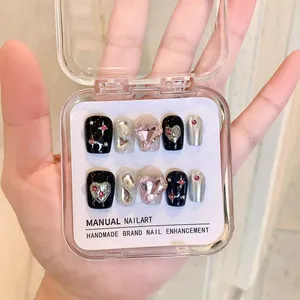 Handmade press-on nails featuring dark heart designs and glitter diamonds in 10-piece set