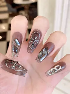 Detail of coffee brown jelly press-on nails with silver crosses and chain accents