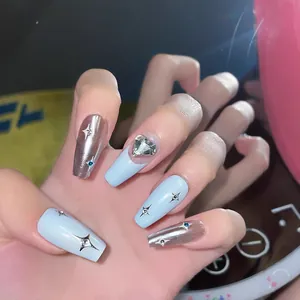 Handmade press-on nails in blue and silver with star decals and heart rhinestone