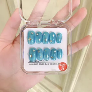 Faux ongles œil de chat bleus avec motifs d'étoiles argentées et détails en strass