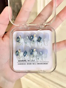 Detalle de uñas postizas con degradado azul, rosas 3D y brillantes diamantes de imitación