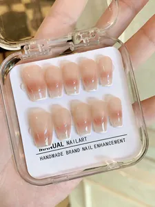 Detail handgefertigter Ombre-Nägel in Nude-Rosa im klaren Aufbewahrungskasten