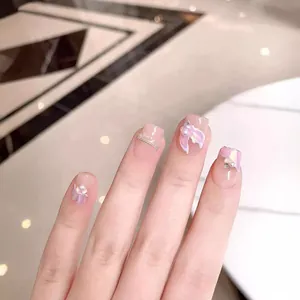 Handmade mermaid style press-on nails in nude pink with purple floral and pearl accents