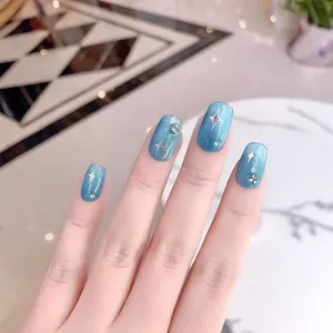 Faux ongles œil-de-chat bleus avec motifs d'étoiles argentées et strass étincelants