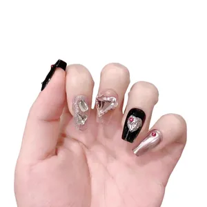 Handmade press-on nails with pink glitter, black glossy finish, and heart-shaped crystals