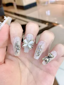 Macro view of Baroque style press-on nails with 3D butterfly, moon, and pearl charms