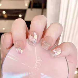 Pink mermaid style press-on nails with pearls, shell textures and metallic chains