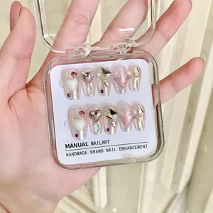 Faux ongles faits main avec cœurs mocha et paillettes effet œil de chat rose
