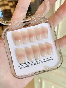 Close-up of handmade pink blush press-on nails in a clear storage gift box