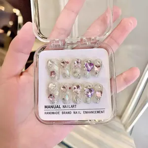 Sparkly silver handmade press-on nails with 3D star and heart charms in a clear box