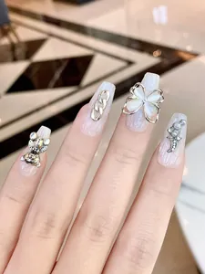 Macro shot of 3D bear and flower charms on white pearl textured press-on nails